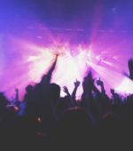 concert with purple lights and lots of people in the audience