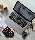 laptop surrouded by art supplies