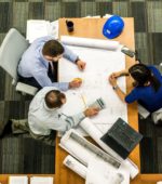 three architects in an office building working on plans