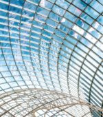 the curved glass and metal architectural ceiling of a museum