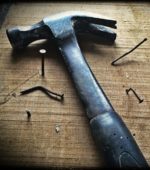 hammer on wood with several bent nails