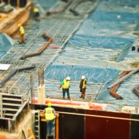 overview of a large commercial construction zone with workers and pipes