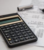 calculator, pen and papers with statistical figures