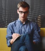 young man working while on a couch