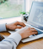 hands typing on a laptop
