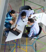 colleagues discuss work in a modern tech office