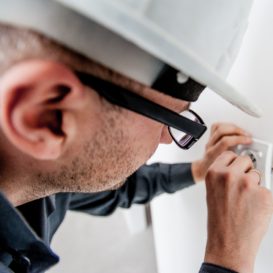 electrician in hard hat installing socket