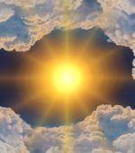 bright sun peeks out from the middle of darkened clouds