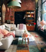 lush interior decor with plants, white couch and brick wall