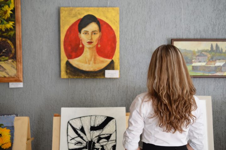 curator in a gallery deciding which art to include on the wall