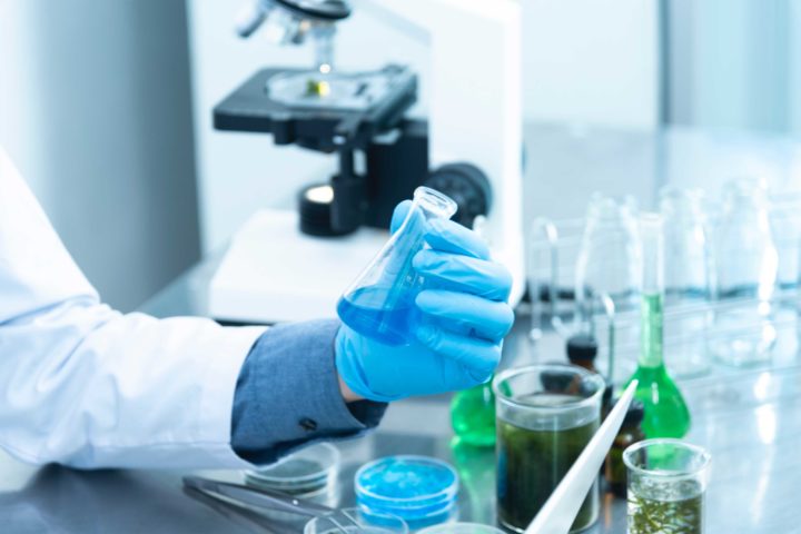 Medical and Clinical Laboratory Technician examines specimen in a laboratory