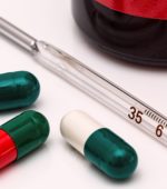 medication in pill form and thermometer