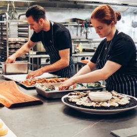 sous chefs work in professional kitchen to create beautiful catering platters