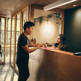 front desk at a boutique hotel with a guest speaking with the employee