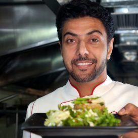 restaurant server holds out place of food with a delicious salad