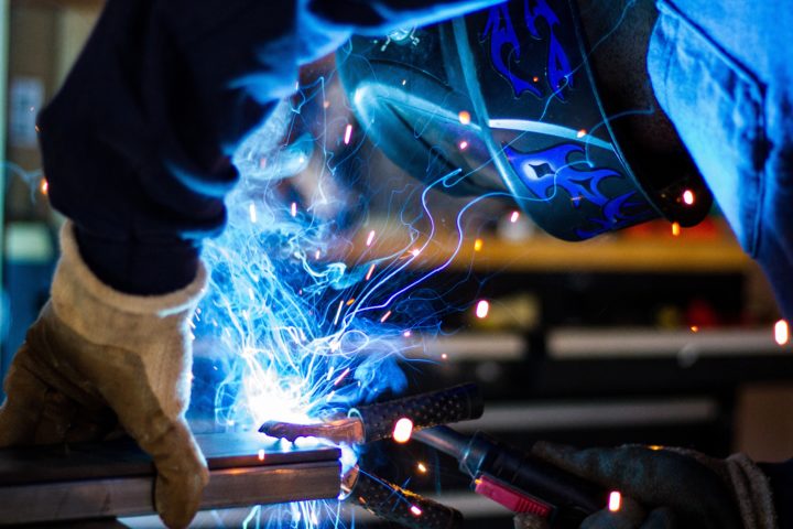 welder holds torch to metal