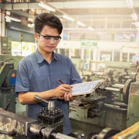 worker holding clipboard in manufactuing plant