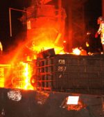 steel mill workers pour molten metal