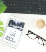 flatlay of keyboard coffee mug glasses and phone