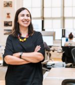manager stands proudly in office