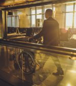 helper pushes wheelchair in airport