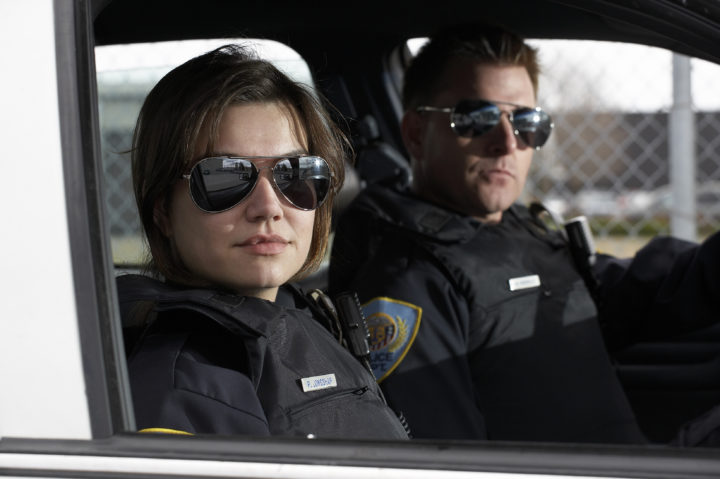 Police and Sheriff's Patrol Officers sit in patrol car