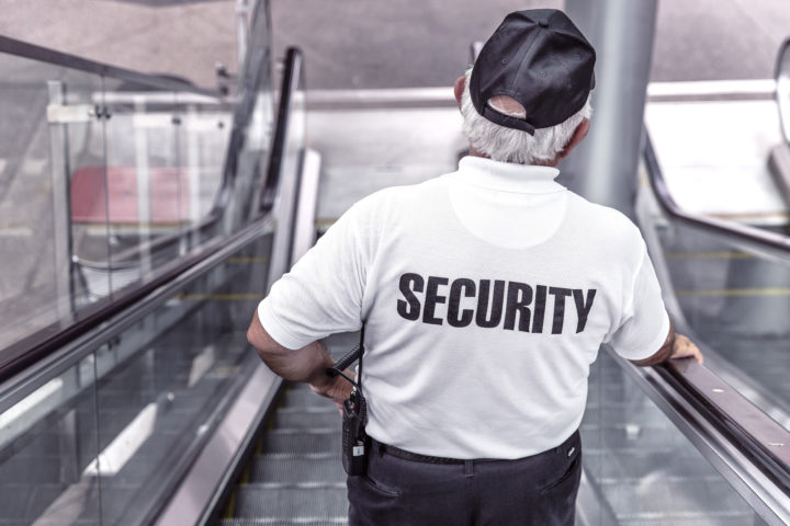 Security Guard going down escalator in shopping mall