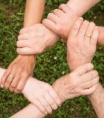 five hands interlocked at the wrists