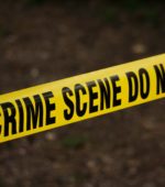 yellow police tape reads crime scene do not cross